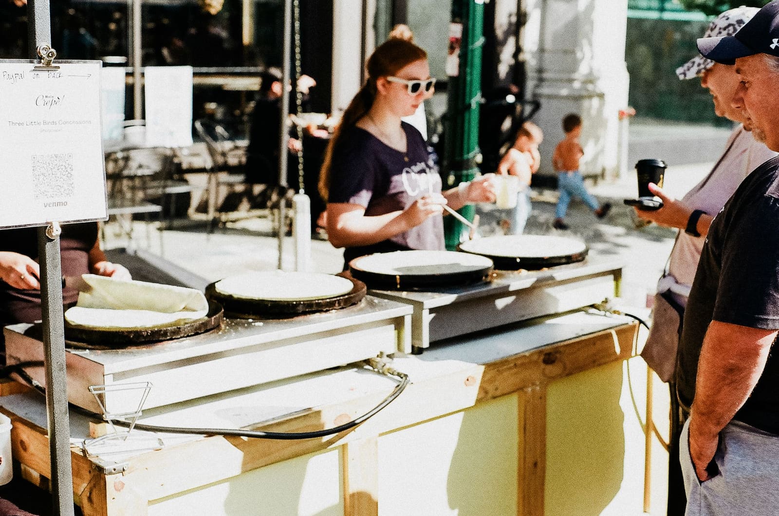Crêpière en plein service sur un stand en plein air