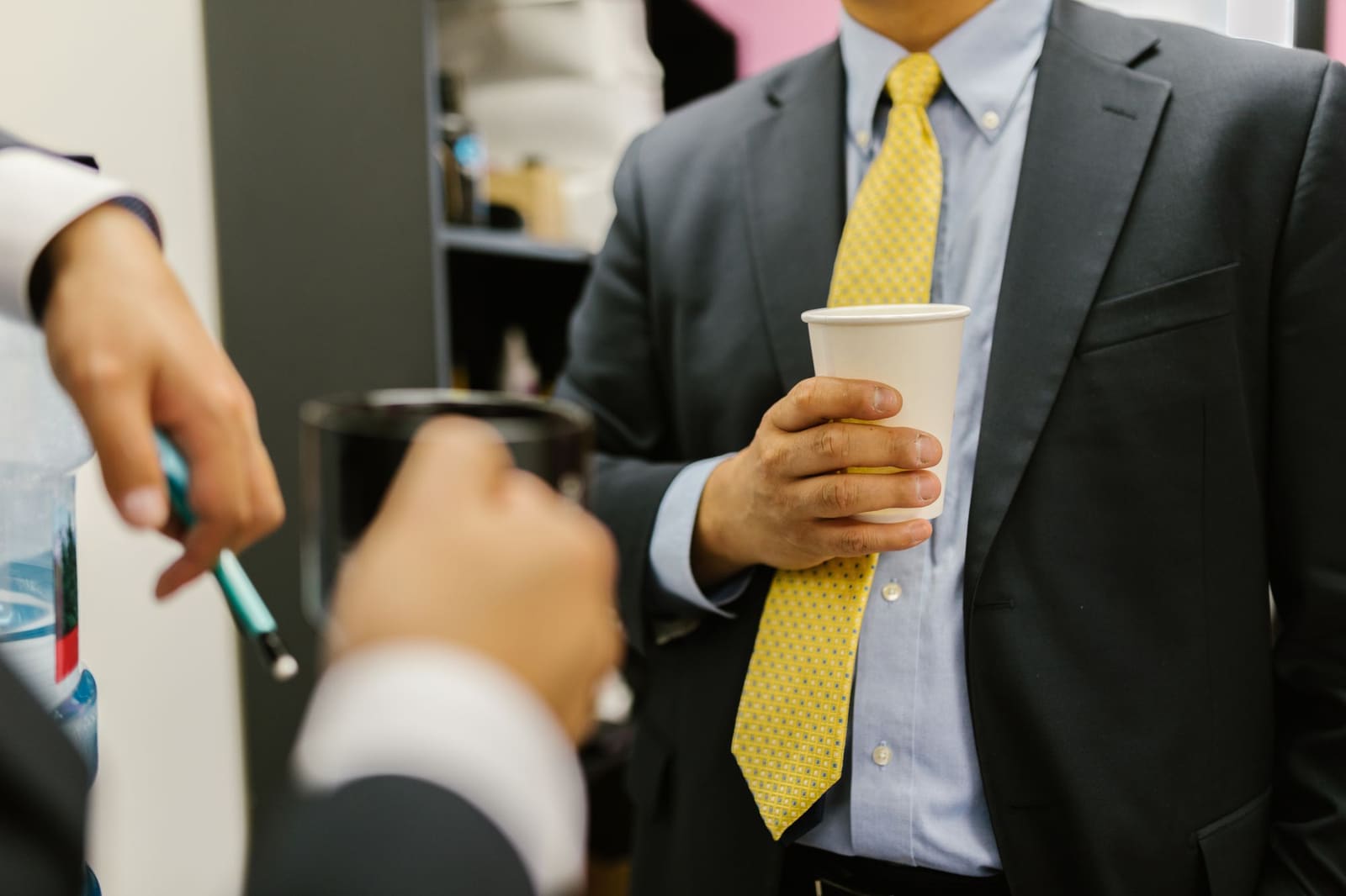 Professionnels en tenue de bureau, gobelet de café à la main